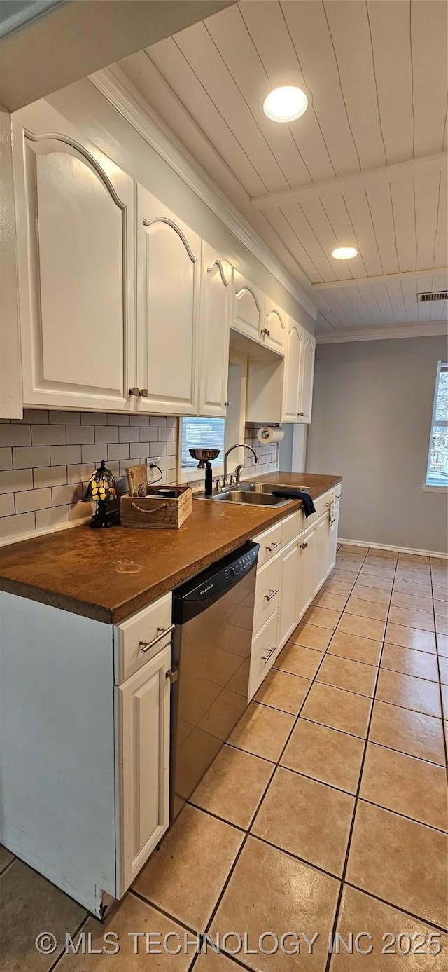 kitchen featuring white cabinetry, sink, backsplash, light tile patterned flooring, and stainless steel dishwasher