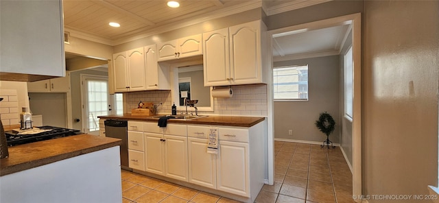 kitchen with sink, white cabinets, butcher block counters, and tasteful backsplash