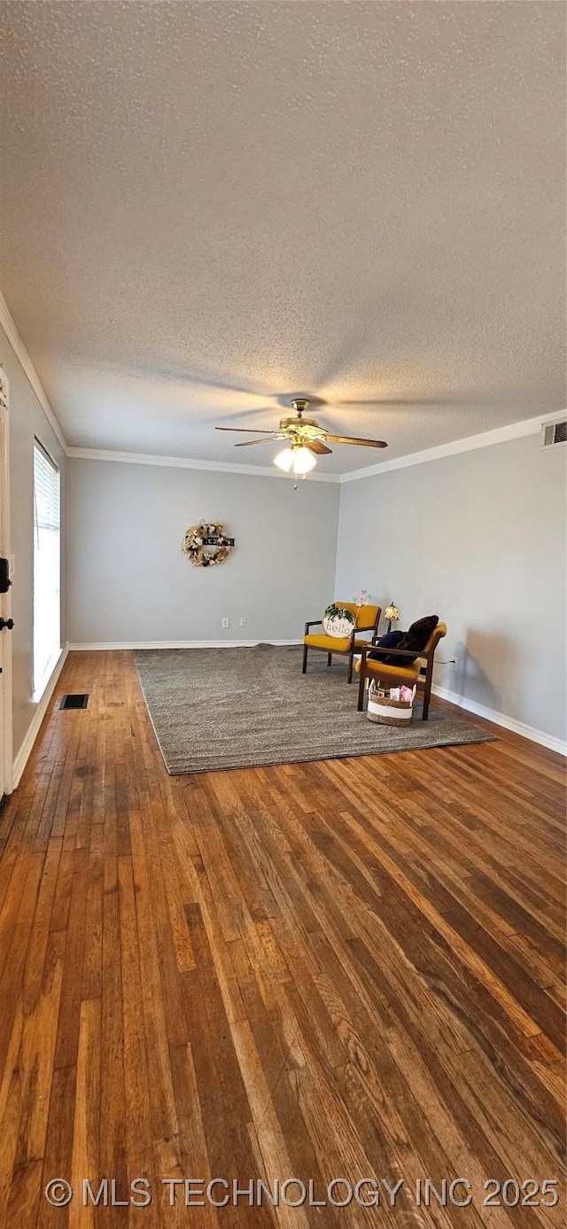 sitting room featuring a textured ceiling, ceiling fan, ornamental molding, and hardwood / wood-style floors