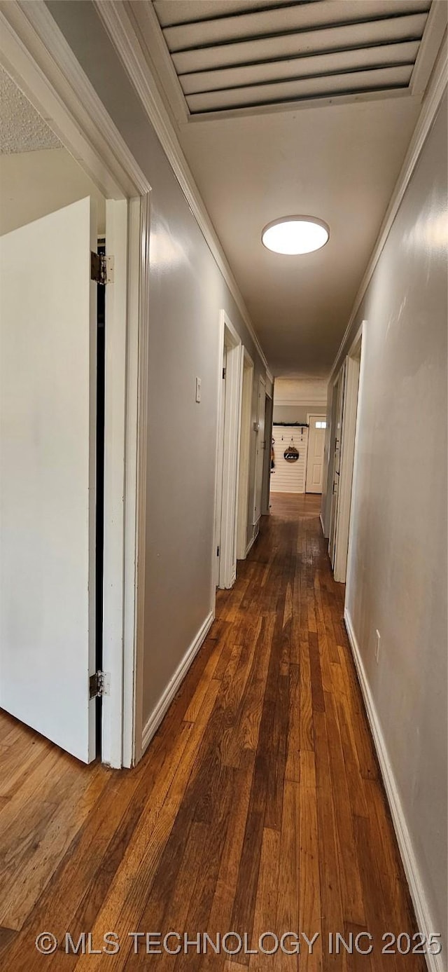 hall featuring dark wood-type flooring and crown molding