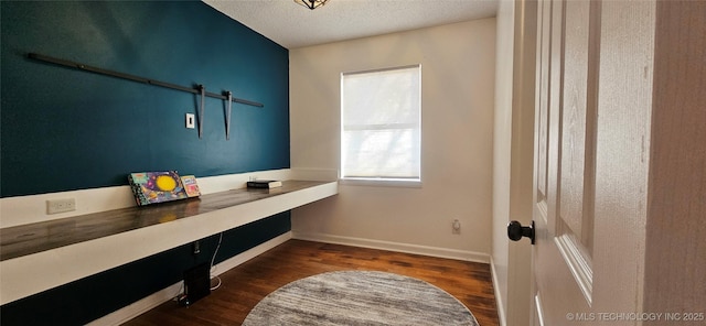 interior space featuring dark wood-type flooring and a textured ceiling