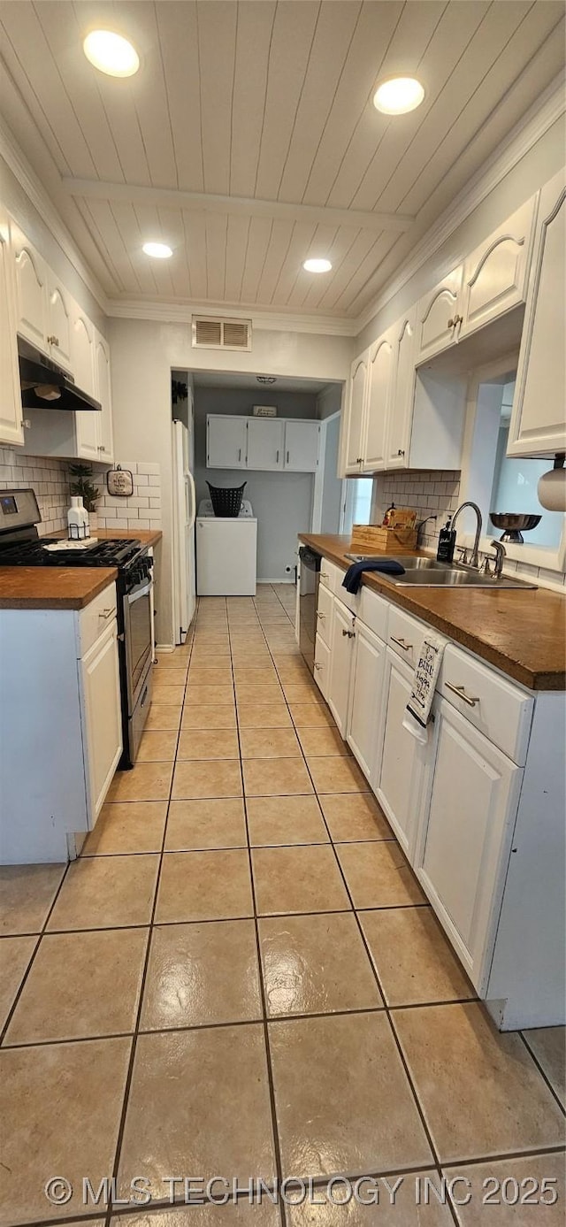 kitchen featuring tasteful backsplash, appliances with stainless steel finishes, white cabinets, and wooden counters