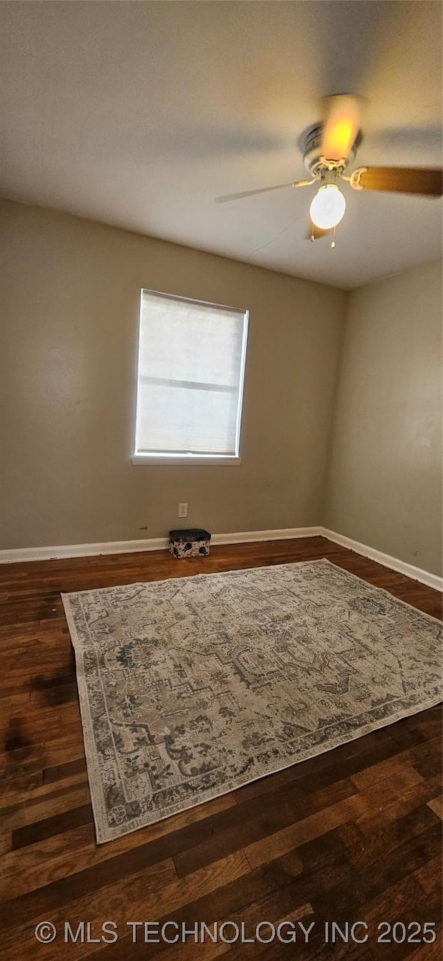 spare room featuring ceiling fan and dark hardwood / wood-style floors