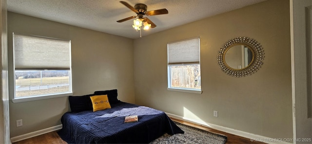 bedroom featuring ceiling fan, a textured ceiling, and hardwood / wood-style floors