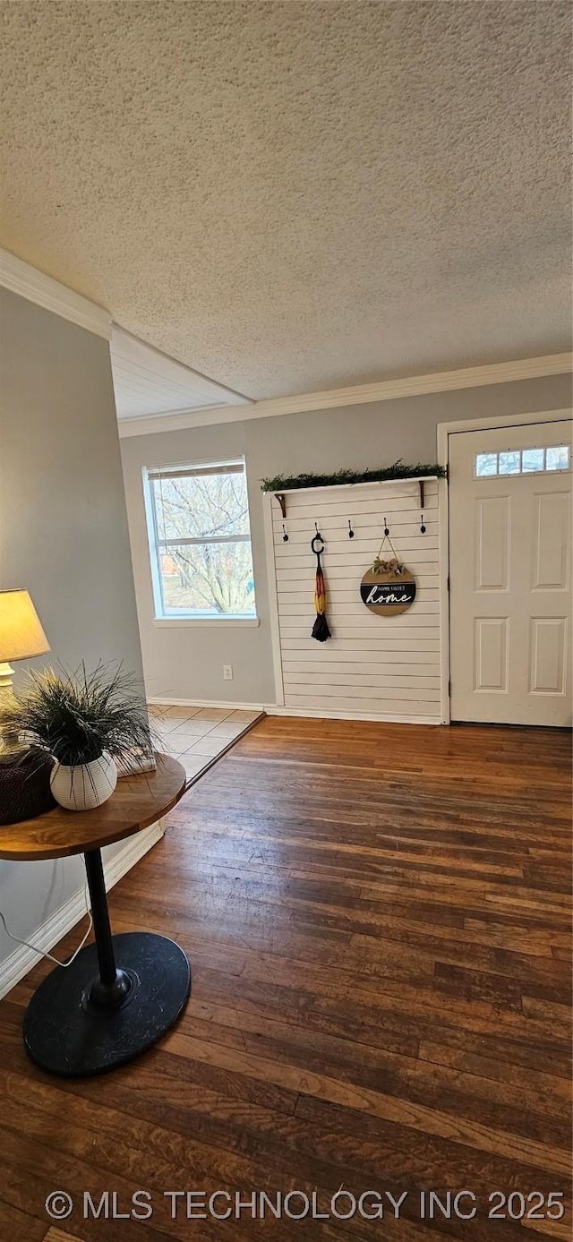 foyer entrance with a textured ceiling, crown molding, and hardwood / wood-style flooring