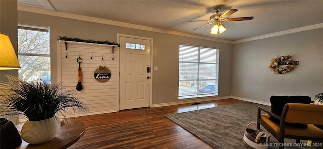 foyer entrance featuring a textured ceiling, dark hardwood / wood-style flooring, crown molding, and plenty of natural light