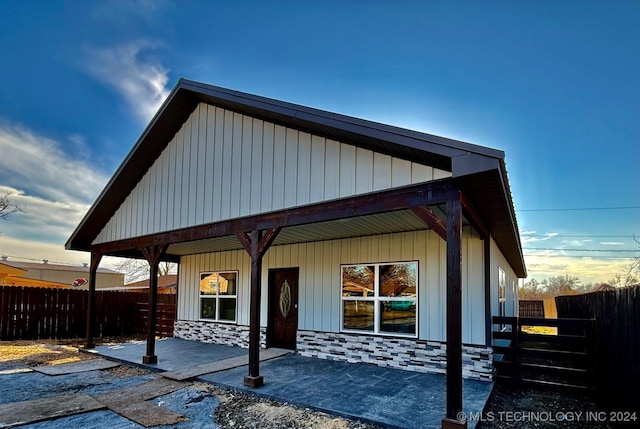 back house at dusk with a porch