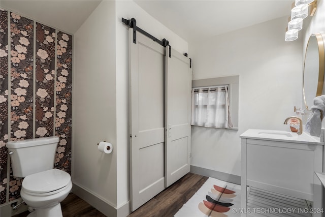 bathroom with vanity, toilet, and hardwood / wood-style flooring