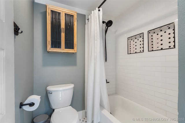 bathroom featuring shower / tub combo and toilet