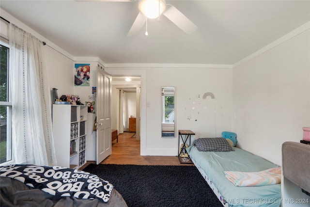 bedroom featuring ceiling fan, hardwood / wood-style flooring, and crown molding