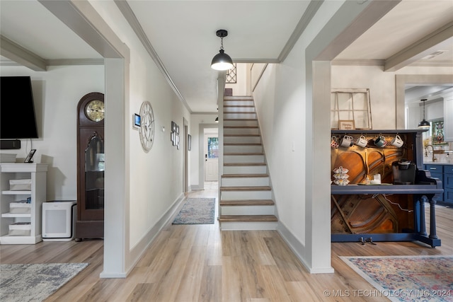 foyer entrance featuring ornamental molding and light hardwood / wood-style floors