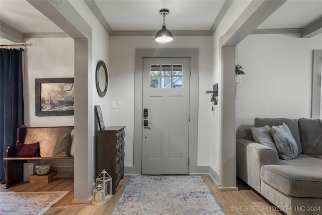 entryway featuring ornamental molding and light wood-type flooring