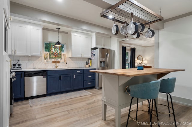 kitchen featuring wood counters, white cabinetry, appliances with stainless steel finishes, decorative light fixtures, and blue cabinets