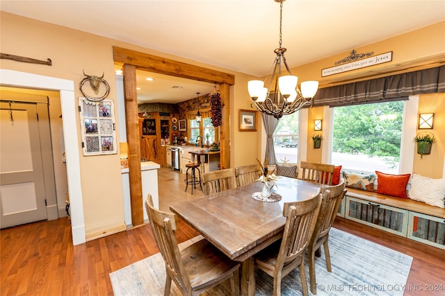 dining space with hardwood / wood-style floors and a chandelier