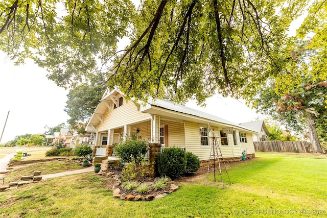 view of home's exterior with a lawn and a porch