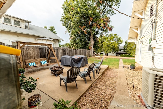 view of patio / terrace featuring cooling unit, a grill, and a fire pit