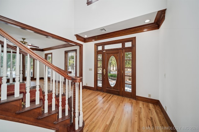 entrance foyer with ceiling fan, hardwood / wood-style flooring, and crown molding