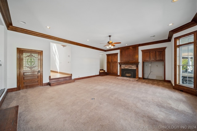 unfurnished living room featuring light carpet, ceiling fan, a healthy amount of sunlight, and crown molding