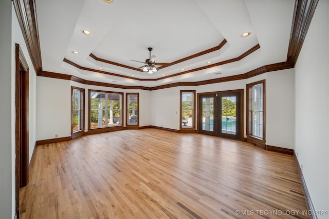 empty room with a healthy amount of sunlight, light hardwood / wood-style floors, and crown molding