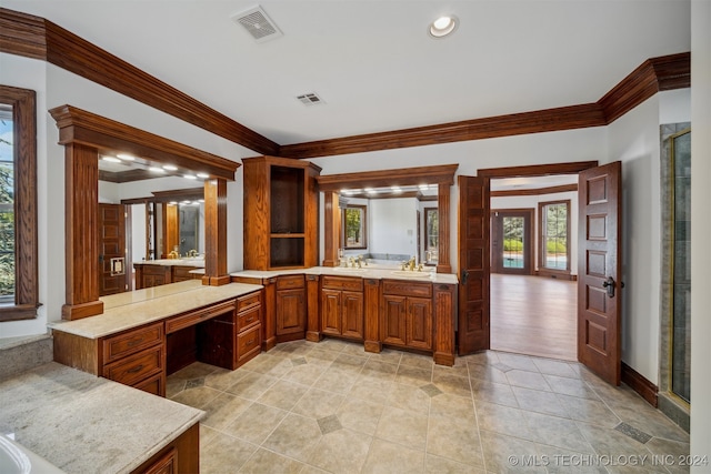 kitchen featuring kitchen peninsula, ornamental molding, and sink