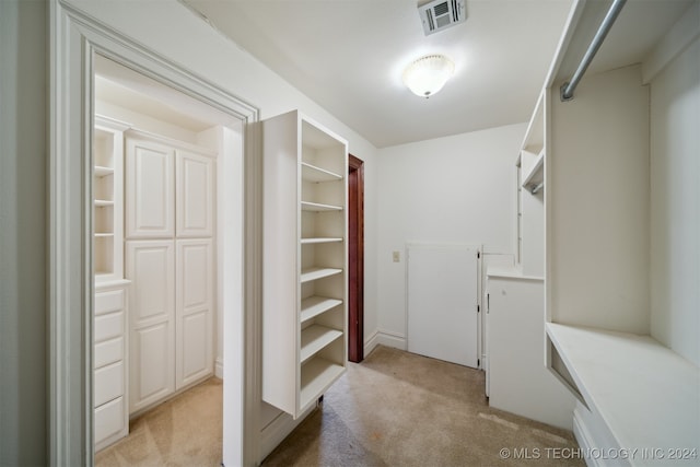 walk in closet featuring light carpet