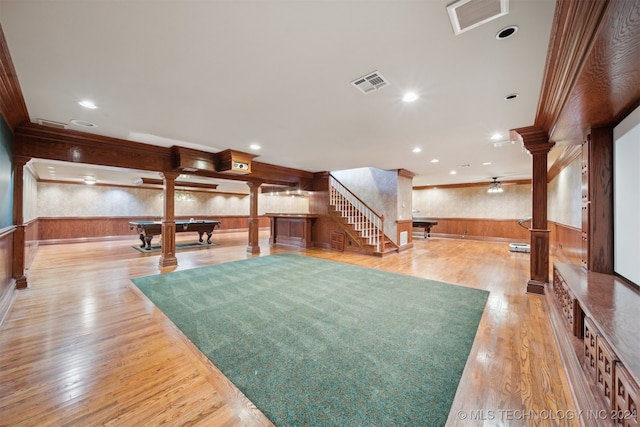 interior space featuring light hardwood / wood-style floors, wooden walls, billiards, crown molding, and ornate columns