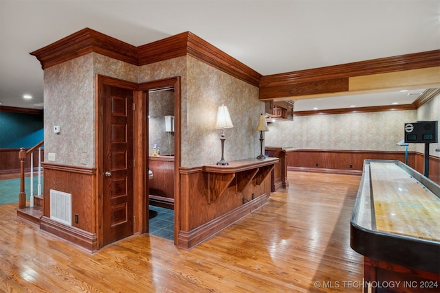 bar featuring ornamental molding and wood-type flooring