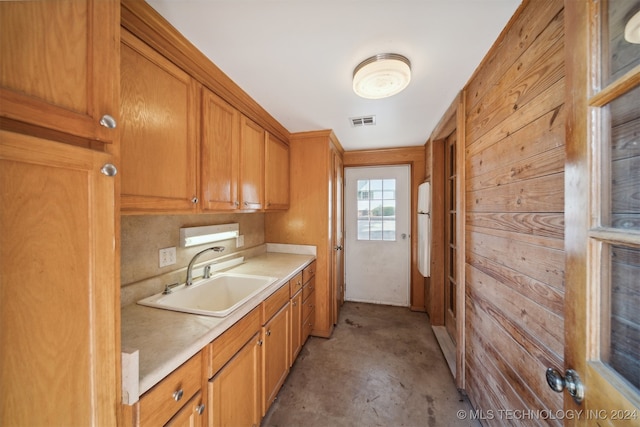 kitchen featuring wood walls and sink