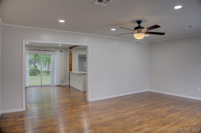 empty room featuring dark wood-type flooring and ornamental molding