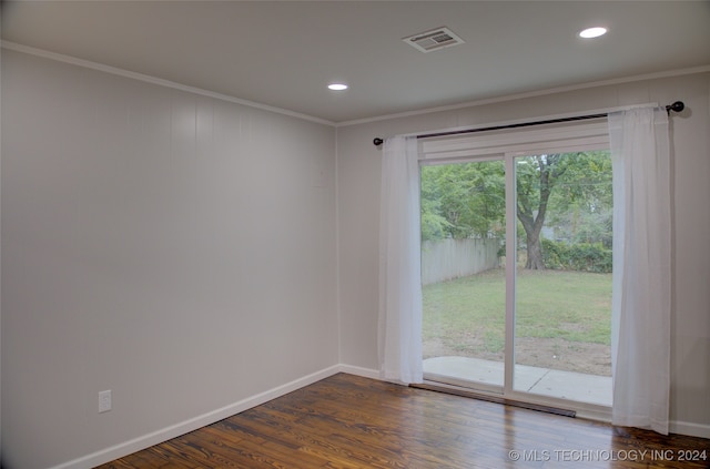 empty room featuring dark hardwood / wood-style floors and crown molding