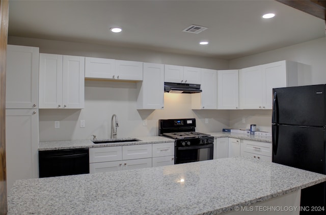 kitchen with white cabinets, sink, light stone counters, and black appliances