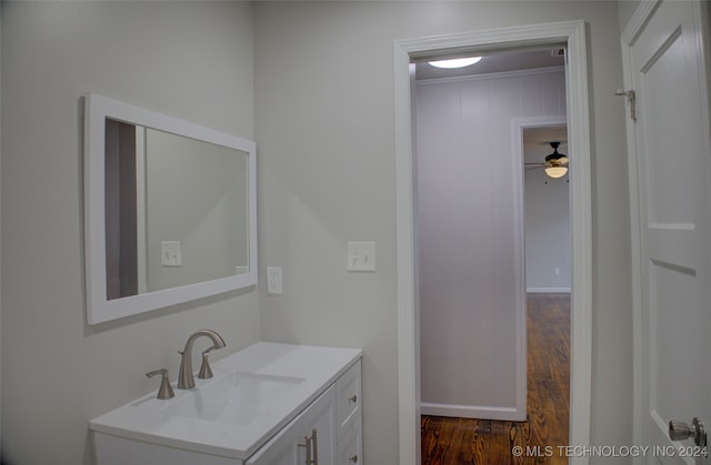 bathroom featuring ceiling fan, hardwood / wood-style floors, vanity, and crown molding