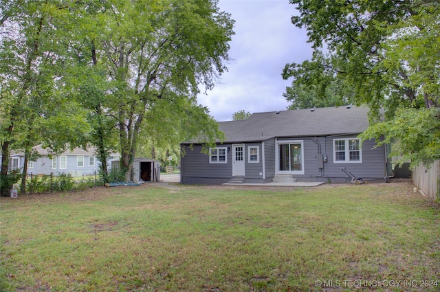 back of house featuring a lawn