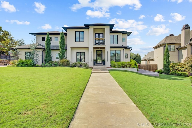 view of front of property featuring a balcony and a front yard