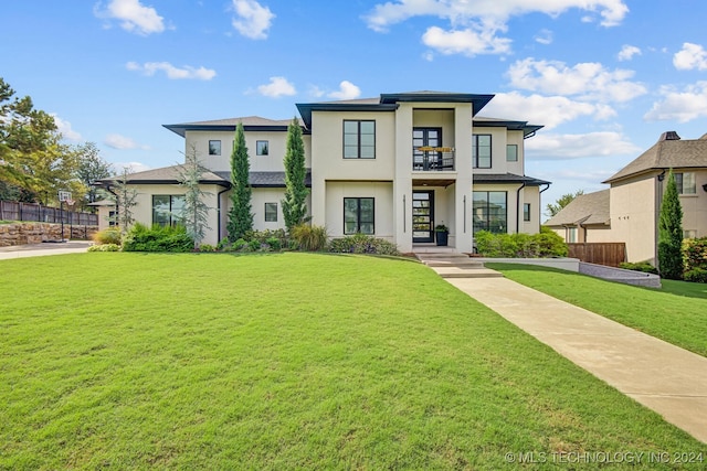 view of front of property featuring a balcony, a porch, and a front yard