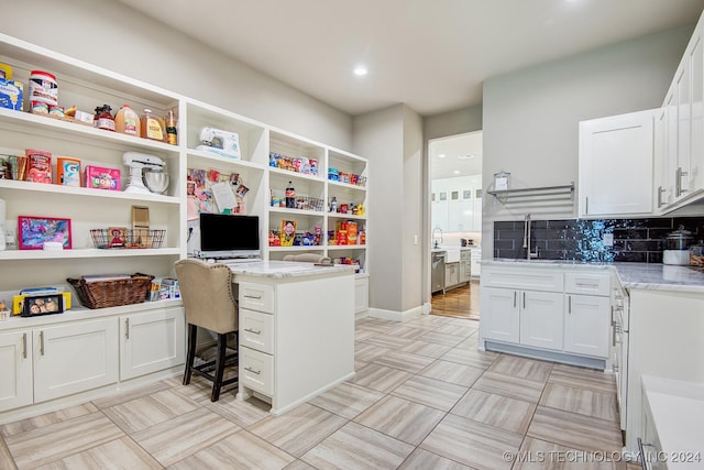 office area featuring built in desk, light hardwood / wood-style floors, and sink