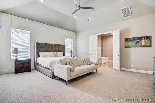 carpeted bedroom featuring ceiling fan, ensuite bath, and high vaulted ceiling