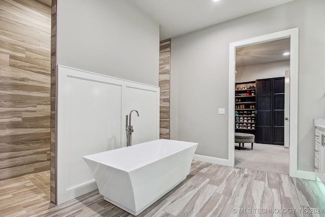 bathroom with independent shower and bath, vanity, and wood-type flooring