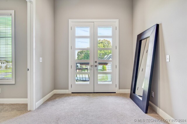 doorway with light carpet and french doors