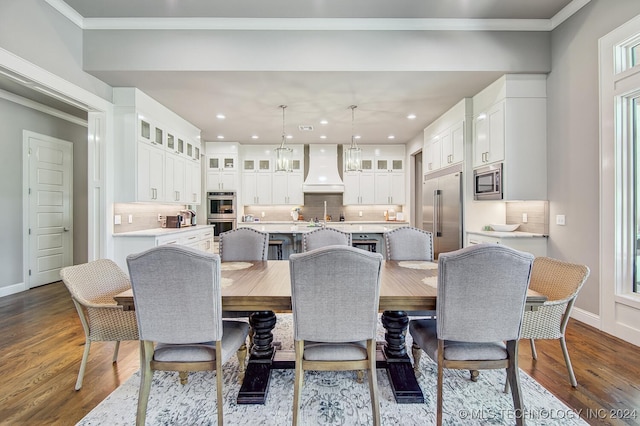 dining area with sink, dark hardwood / wood-style floors, and ornamental molding