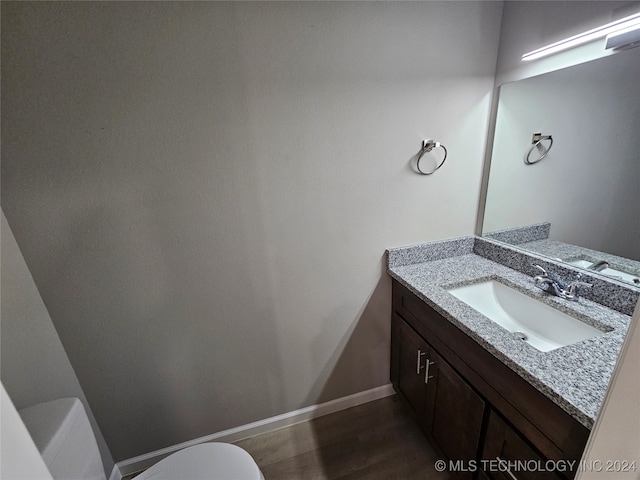 bathroom featuring hardwood / wood-style floors, vanity, and toilet