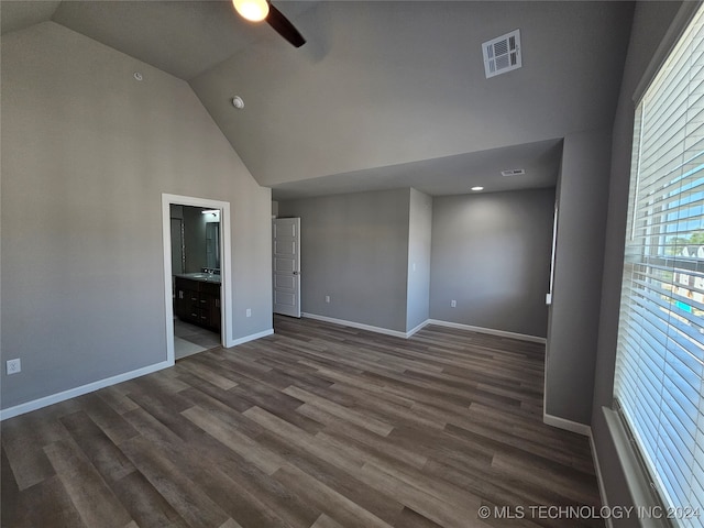 empty room with high vaulted ceiling, ceiling fan, and dark hardwood / wood-style flooring