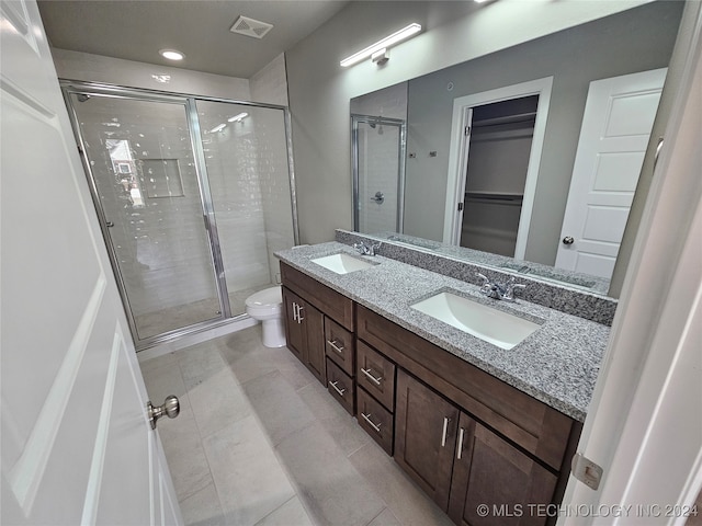 bathroom with tile patterned floors, walk in shower, vanity, and toilet