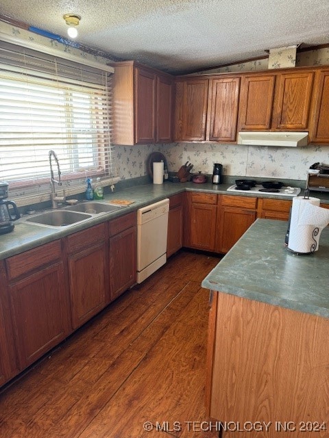 kitchen with a textured ceiling, sink, dark wood-type flooring, and white appliances