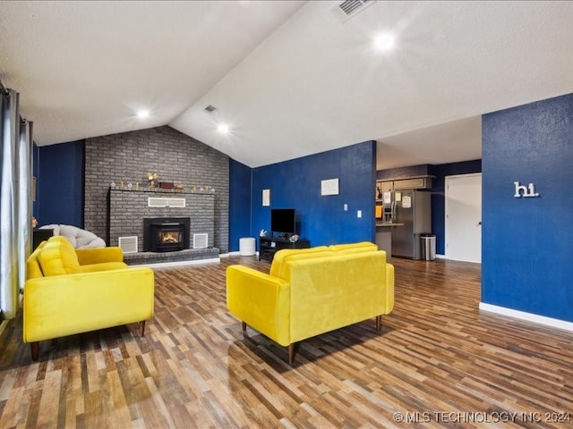 living room featuring a brick fireplace, vaulted ceiling, and hardwood / wood-style floors