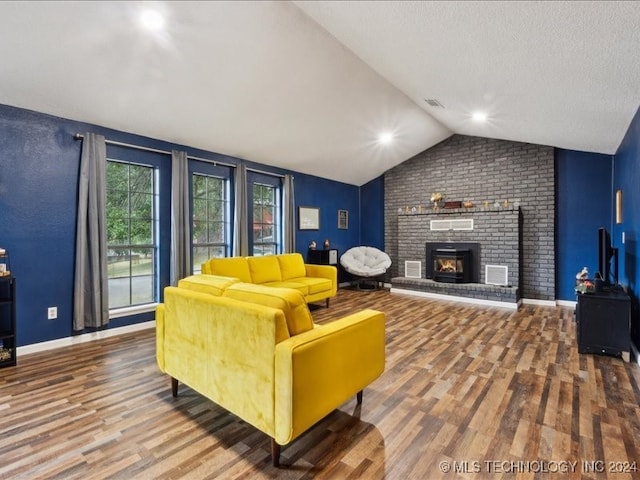 living room featuring a brick fireplace, hardwood / wood-style flooring, and vaulted ceiling