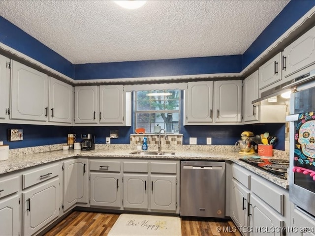 kitchen featuring dark hardwood / wood-style flooring, a textured ceiling, sink, and stainless steel dishwasher