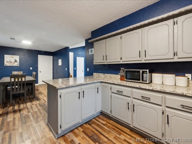 kitchen featuring white cabinets and hardwood / wood-style flooring