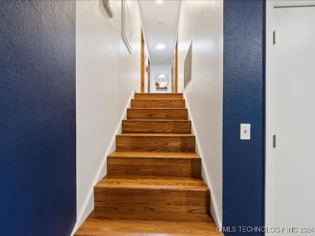 stairs featuring wood-type flooring