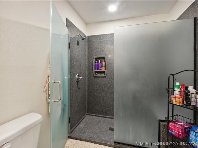 bathroom with toilet and a shower with door